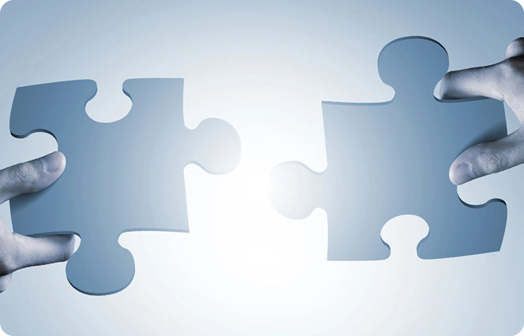 Two people holding puzzle pieces representing seamless SAP integration and data exchange.