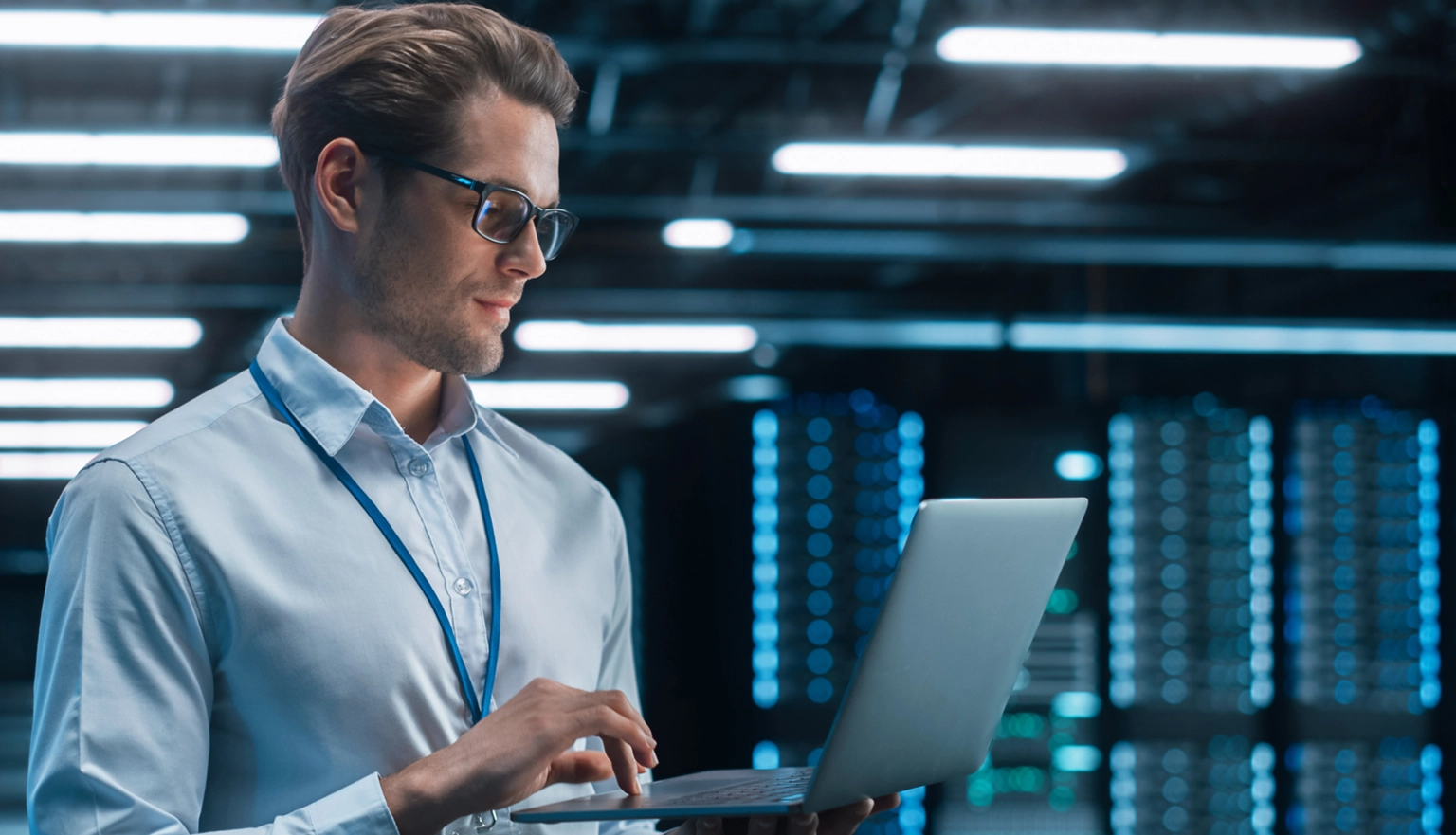 Professional using a laptop in a data center, representing AI-driven data migration and SAP ERP integration.