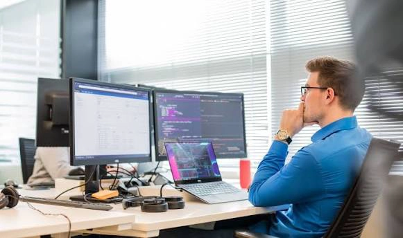 Professional analyzing data on multiple computer screens, illustrating analytics challenges caused by inconsistent master data.